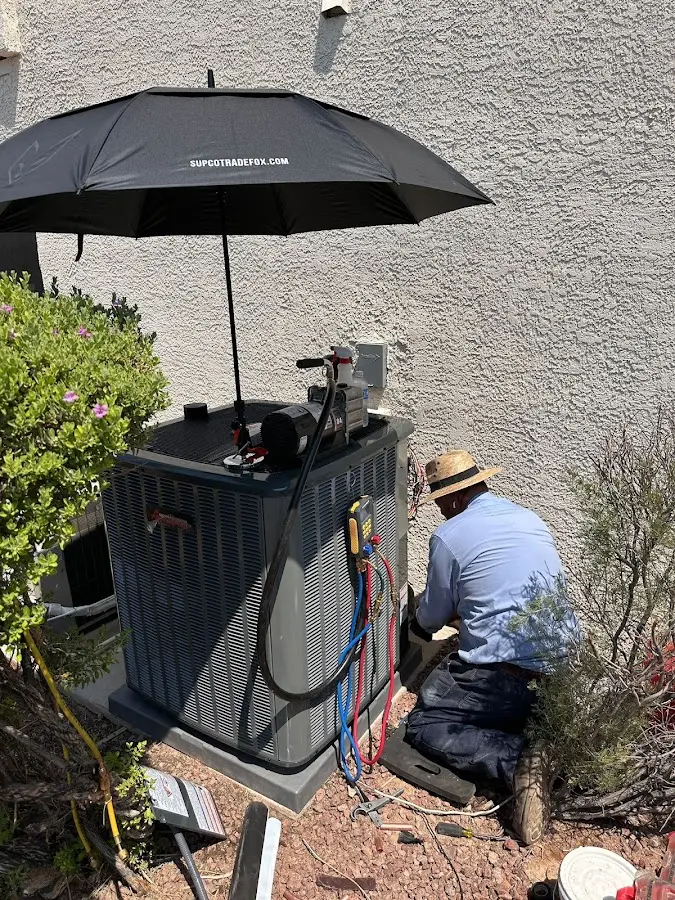 HVAC technician performing outdoor AC maintenance in Twin Lakes